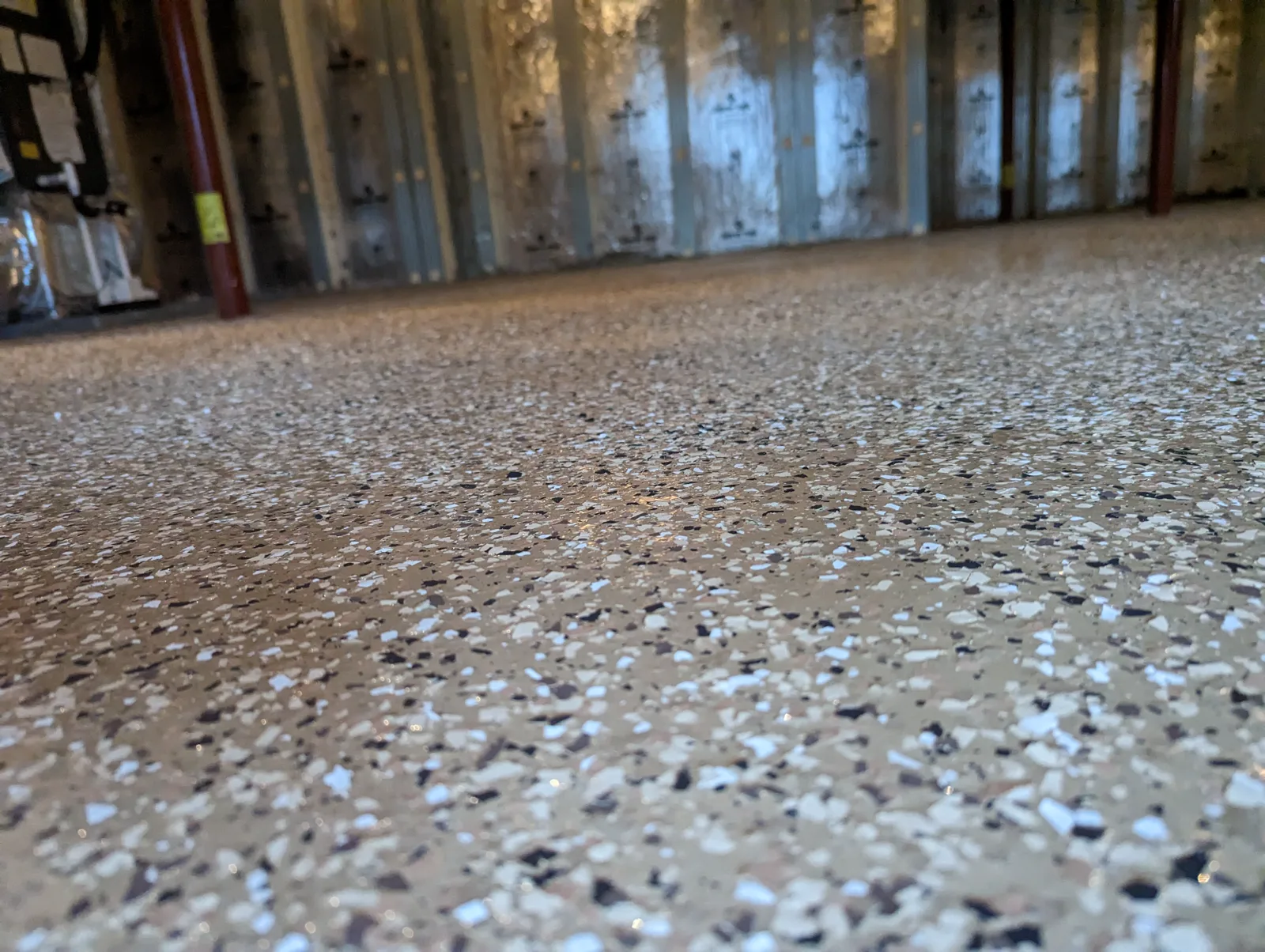 Flake floor coating with a glossy protective topcoat in a workshop space